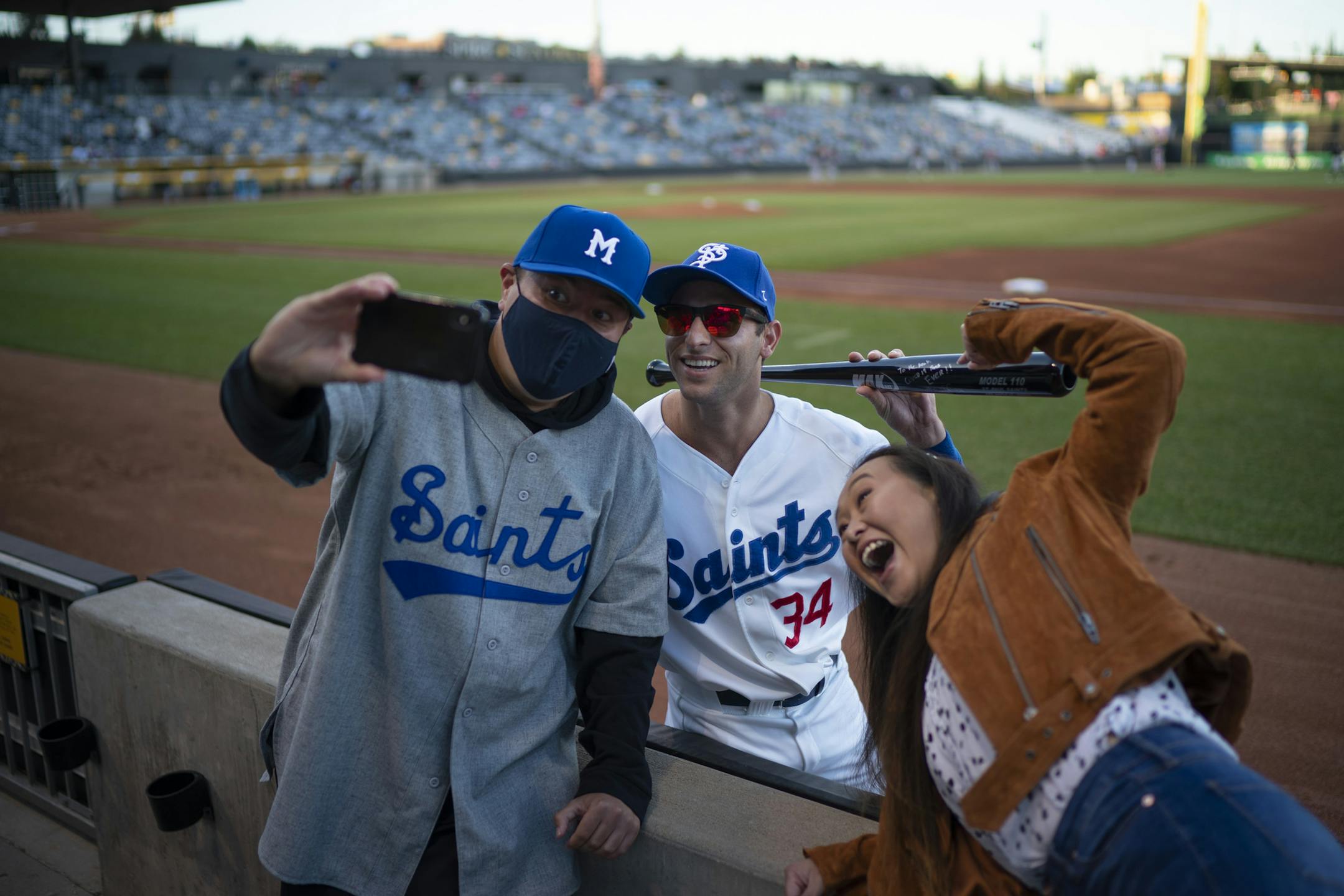 Daniel Yang and his wife, Bauj Chu-Yang-Heu, posed for a selfie with Saints infielder Mikey Reynolds after he gave them an autographed bat before Thursday night's game. The couple are huge fans of the Saints and got to know Reynolds over the course of the season. ] JEFF WHEELER • jeff.wheeler@startribune.com The St. Paul Saints played the Fargo-Moorhead Redhawks in their final game of the season Thursday night, September 10, 2020 at CHS Field in St. Paul.