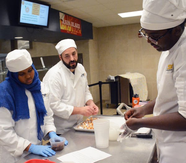Matt Deutsch, middle, and two students help prepare cookies for the judges to taste. Photo by Ruth Dunn