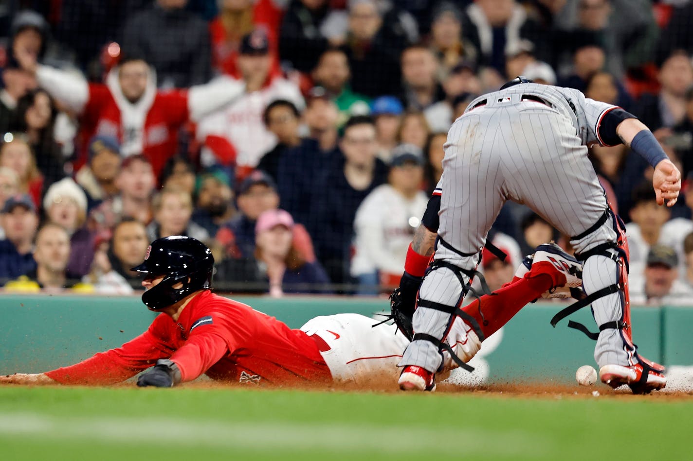 Boston Red Sox's Enrique Hernandez scores against Minnesota Twins' Christian Vazquez, right, on a fielders choice during the eighth inning of a baseball game, Tuesday, April 18, 2023, in Boston. (AP Photo/Michael Dwyer)