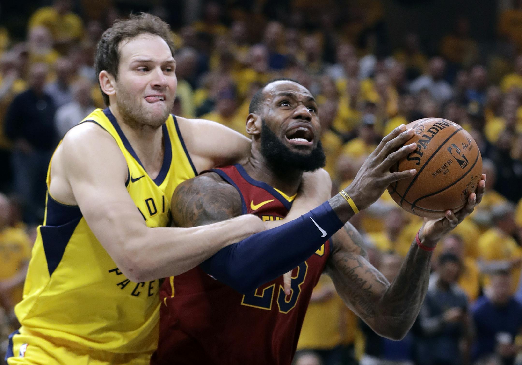 Cleveland Cavaliers' LeBron James, right, is fouled on his way to the basket by Indiana Pacers' Bojan Bogdanovic during the first half of Game 6 of a first-round NBA basketball playoff series, Friday, April 27, 2018, in Indianapolis. (AP Photo/Darron Cummings)