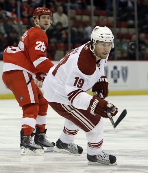 Phoenix Coyotes' Shane Doan (19) keeps his eye on the puck as Detroit Red Wings defenseman Brian Rafalski (28) defends during the first period of an N