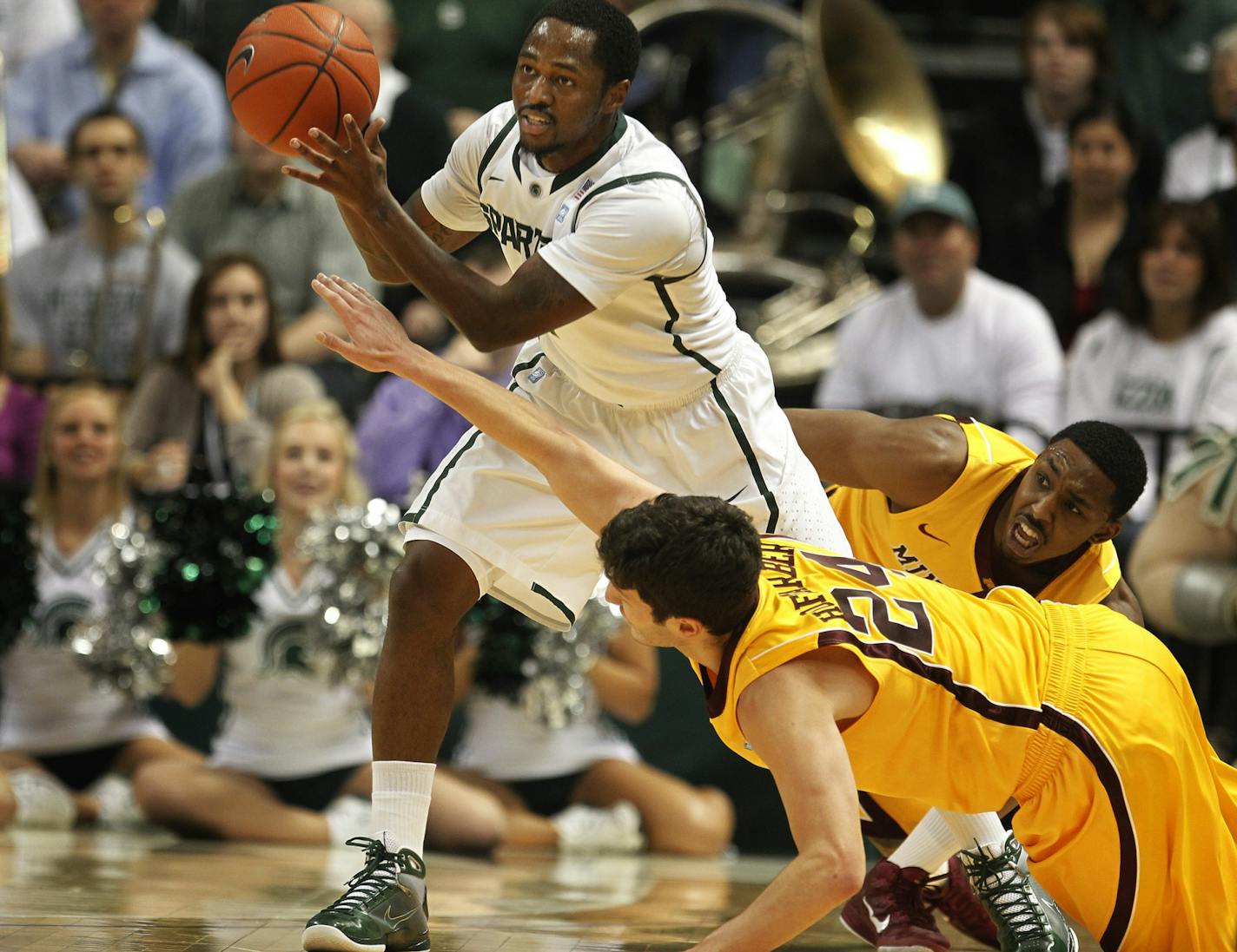 Michigan State's Kalin Lucas eluded the scrambling defense of the Gophers' Blake Hoffarber (24) and Al Nolen during the Spartans' 71-62 victory Friday.