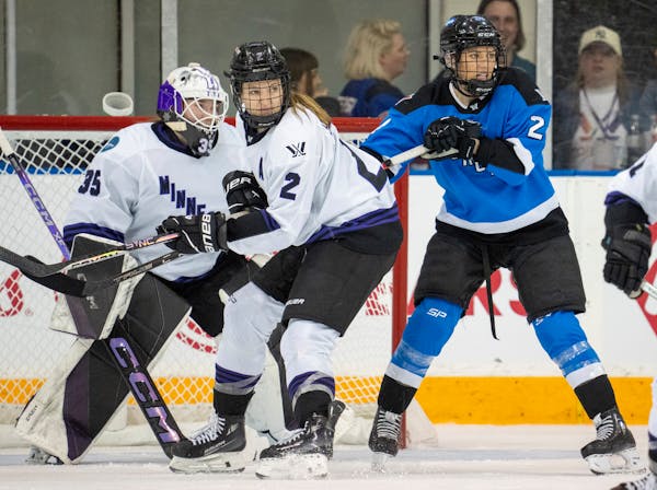 Toronto's Natalie Spooner, right, battles for position with Minnesota's Lee Stecklein (2) in front of goaltender Maddie Rooney during the third period