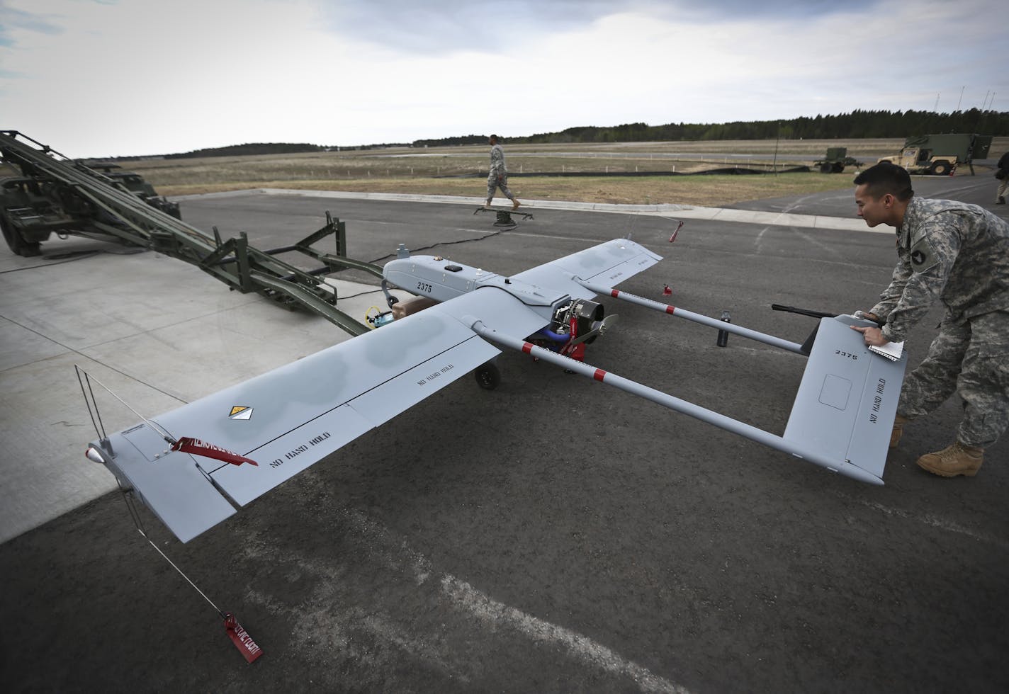 SPC Tri Phu walked around a Shadow System unmanned aircraft used for surveillance and communication in military situations during a media day for the new Camp Ripley Unmanned Aircraft Systems Operations Facility in Little Falls, Minn., on Thursday, May 16, 2013. ] (RENEE JONES SCHNEIDER * reneejones@startribune.com)