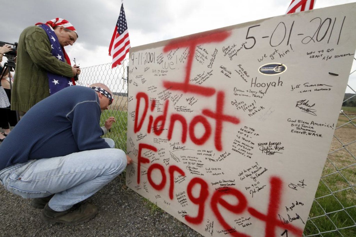 Jeff Ray, right, and Jan Ray of Shanksville, Pa., attach a sign to the fence overlooking the crash site of United Flight 93 in Shanksville, Pa., Monday, May 2, 2011. Osama Bin Laden, the face of global terrorism and mastermind of the Sept. 11, 2001, attacks, was tracked down and shot to death Monday in Pakistan by an elite team of U.S. forces, ending an unrelenting manhunt that spanned a frustrating decade.