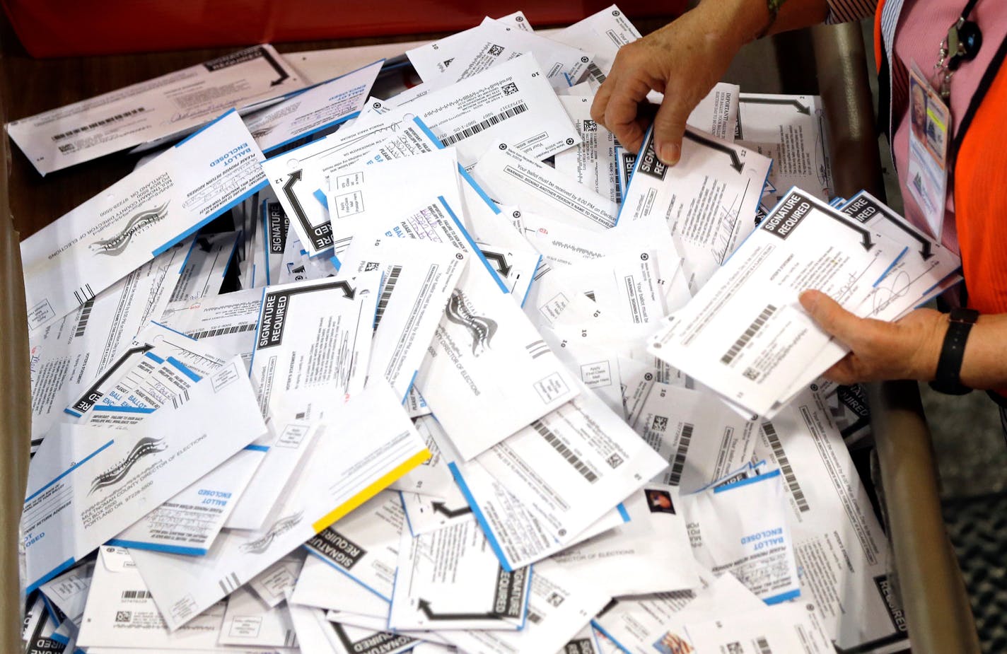 FILE - In this May 17, 2016, file photo, ballots are prepared for counting at Multnomah County election headquarters in Portland, Ore. The coronavirus has knocked presidential primaries back several weeks as officials worry about voters crowding into polling places. If the disease remains a hazard in November, Democrats say there's only one solution to preserve the November election, national voting by mail. (AP Photo/Don Ryan, File)