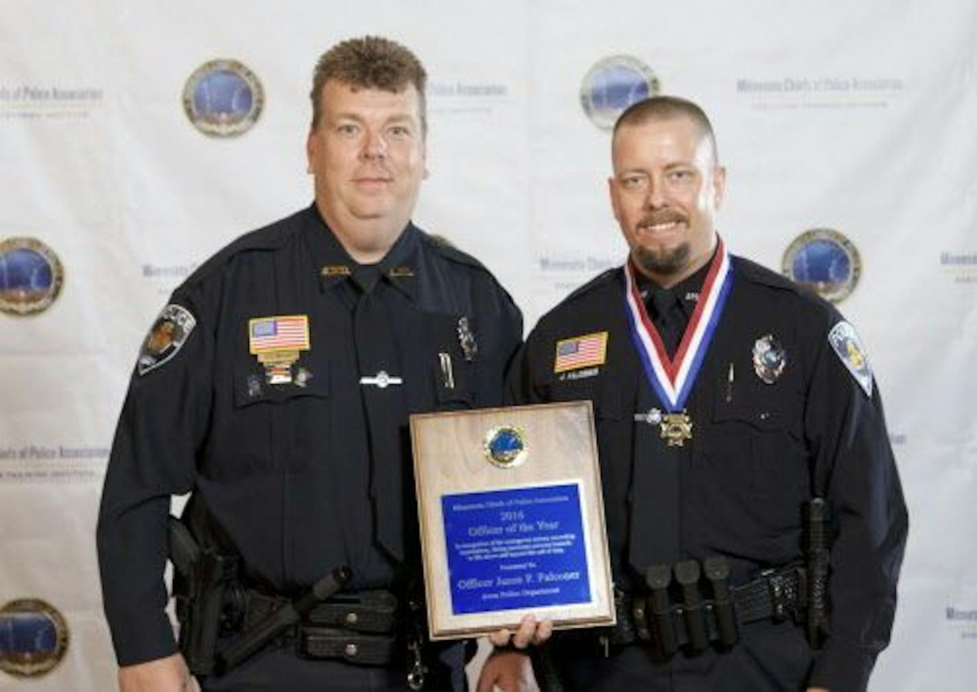 Avon police officer Jason Falconer, right, hold his Office of the Year award, alongside Avon Police Chief Corey Nellis.