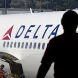 A passenger looks out towards a Delta Air Lines Inc. plane at San Francisco International Airport in San Francisco, California, U.S., on Tuesday, July 26, 2011. Delta Air Lines Inc., the world's second-largest airline, reported a second-quarter profit that trailed analysts' estimates as rising fuel costs damped results. Photographer: David Paul Morris/Bloomberg ORG XMIT: 120065651