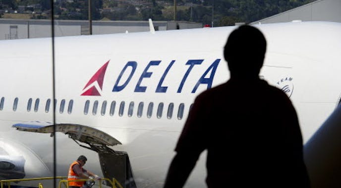 A passenger looks out towards a Delta Air Lines Inc. plane at San Francisco International Airport in San Francisco, California, U.S., on Tuesday, July 26, 2011. Delta Air Lines Inc., the world's second-largest airline, reported a second-quarter profit that trailed analysts' estimates as rising fuel costs damped results. Photographer: David Paul Morris/Bloomberg ORG XMIT: 120065651