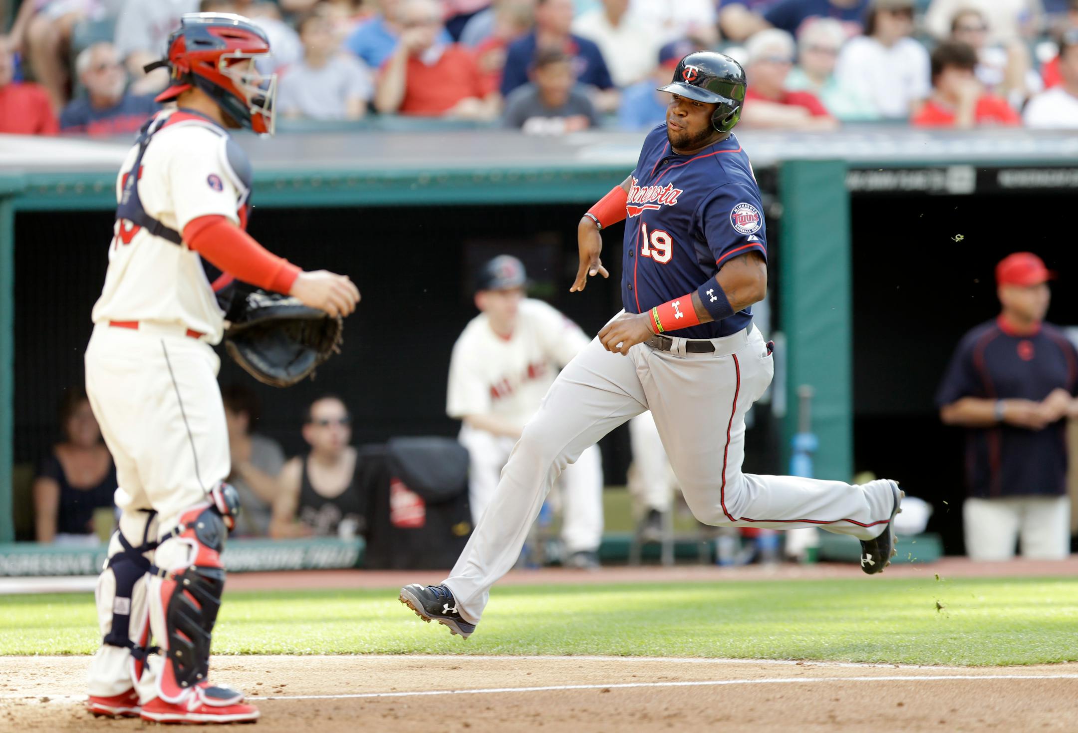 Minnesota Twins' Kennys Vargas (19) scores on an RBI-single from Eddie Rosari in the third inning of a baseball game against the Cleveland Indians, Saturday, May 9, 2015, in Cleveland. Cleveland Indians catcher Roberto Perez watches. (AP Photo/Tony Dejak)