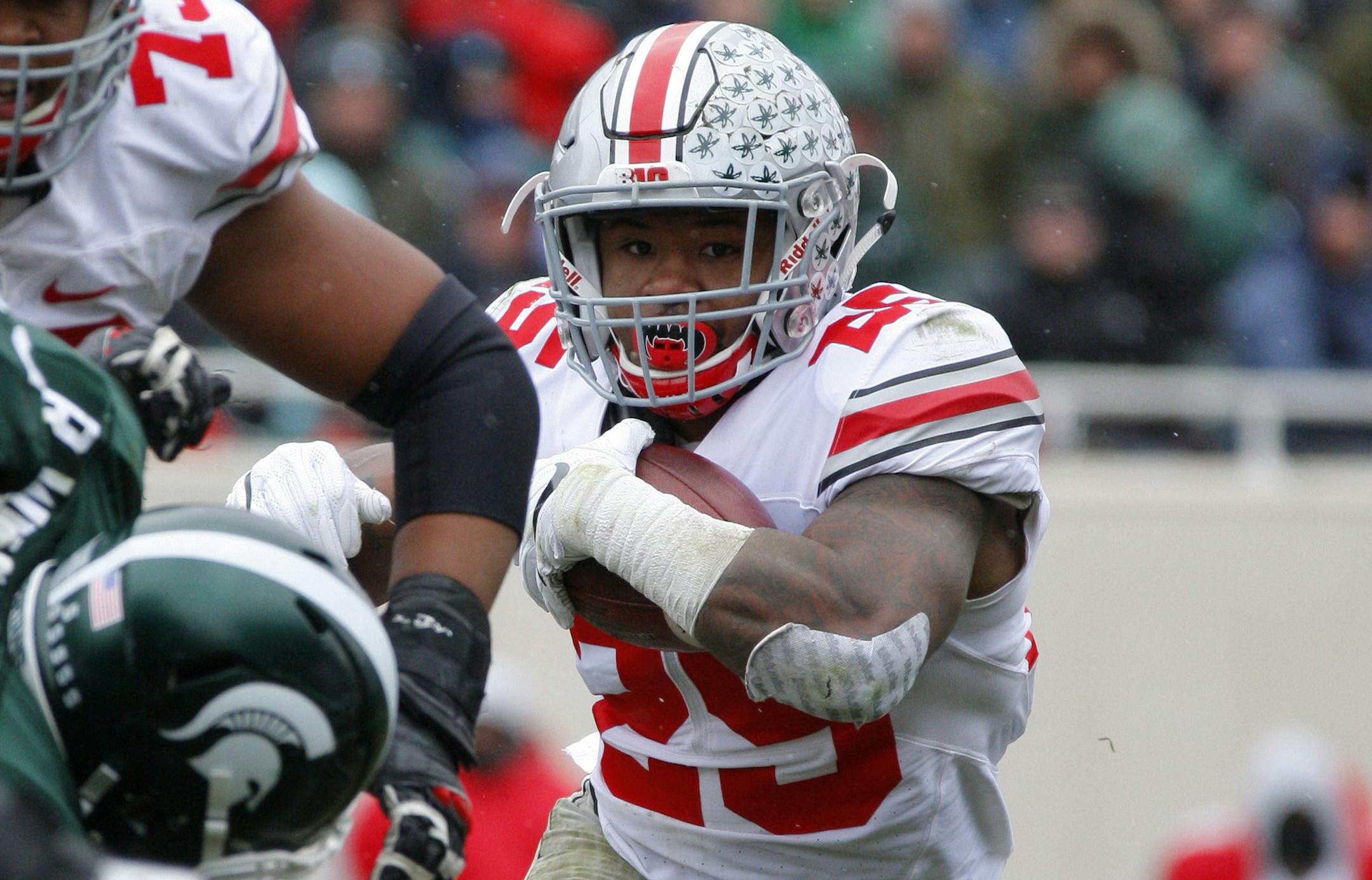 Ohio State's Mike Weber, right, rushes against Michigan State's Raequan Williams during the second quarter half of an NCAA college football game, Saturday, Nov. 19, 2016, in East Lansing, Mich. Ohio State won 17-16. (AP Photo/Al Goldis)