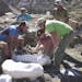 In an undated handout photo, a Denver Museum of Nature & Science team encases pieces of a horned dinosaur in plaster jackets at a new site on the Kaip