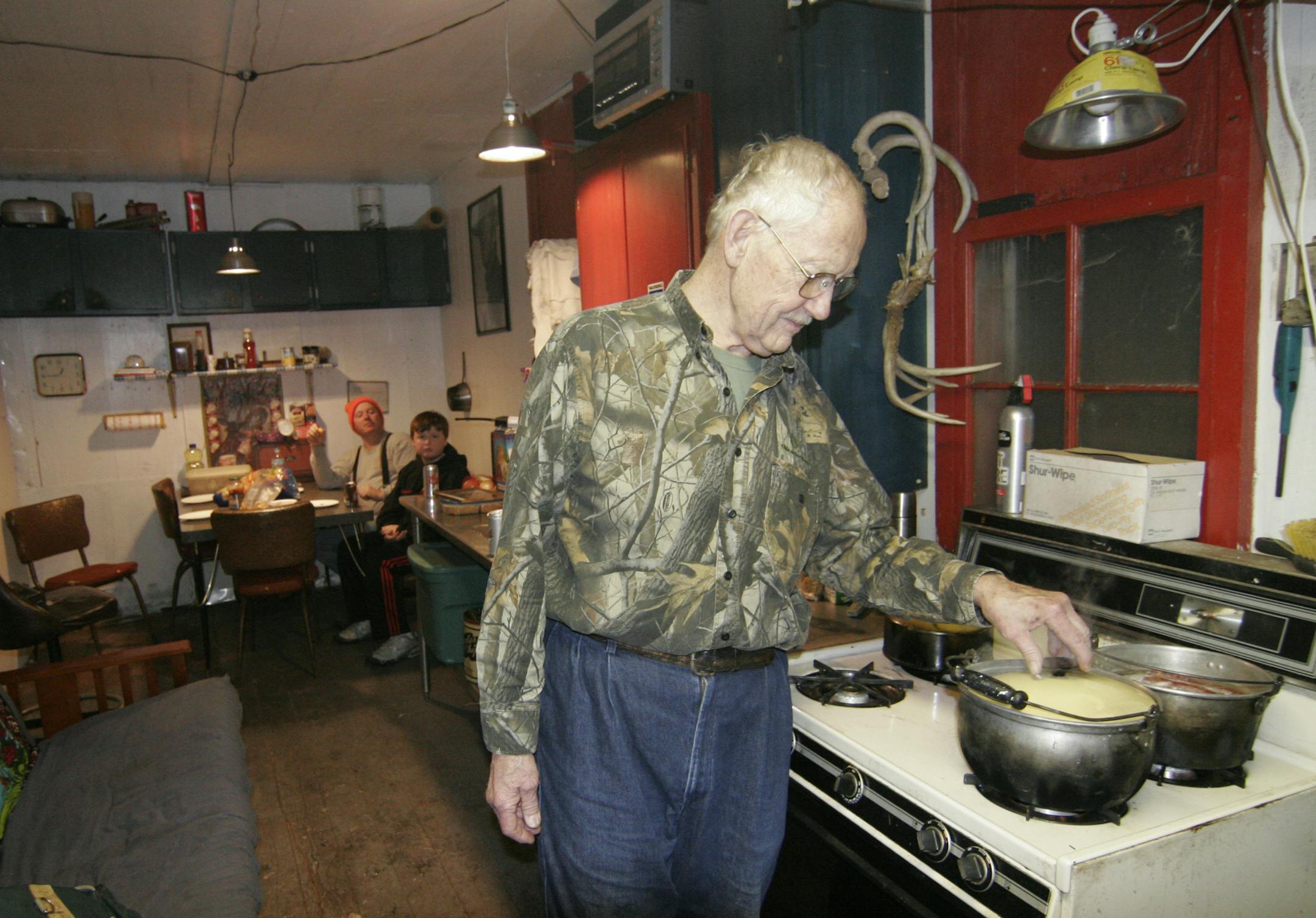 Rick Storck checked dinner on the eve of Minnesota's firearms deer season opener. For nearly 50 years, a a 40-foot long retired wooden railroad car has served as Storck's hunting shack. Photo by Doug Smith/Star Tribune.