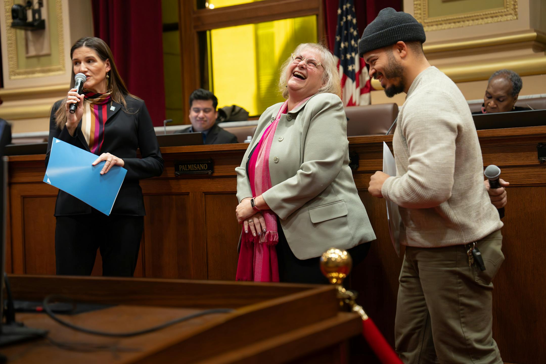 Lisa Goodman smiled as Council Members Linea Palmisano, left, and Jeremiah Ellison, right read a proclamation honoring her Thursday, Dec. 7, 2023.