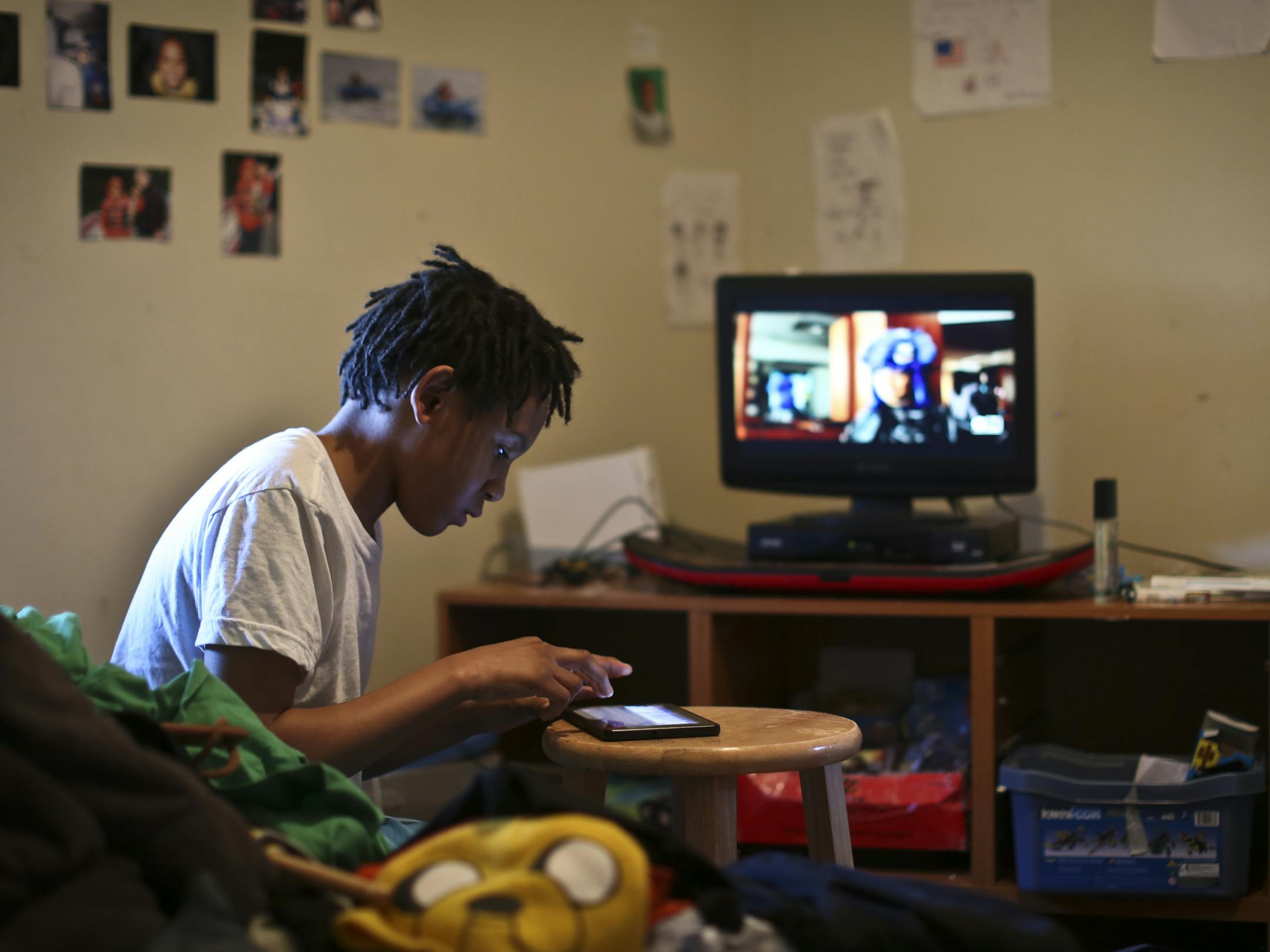 Gianni Griffin-Davis played with his Kindle Fire in hi bedroom soon after he returned home from spending 37 days at the Ramsey County Juvenile Detention Center on Thursday May 23, 2013 in Fridley, Minn. ] (RENEE JONES SCHNEIDER * reneejones@startribune.com)