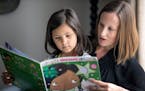 Jenna Cruz and her daughter Esme, 6, of Chaska looked through the book “Esme the Emerald Fairy,” whose main character is a youngster of color.