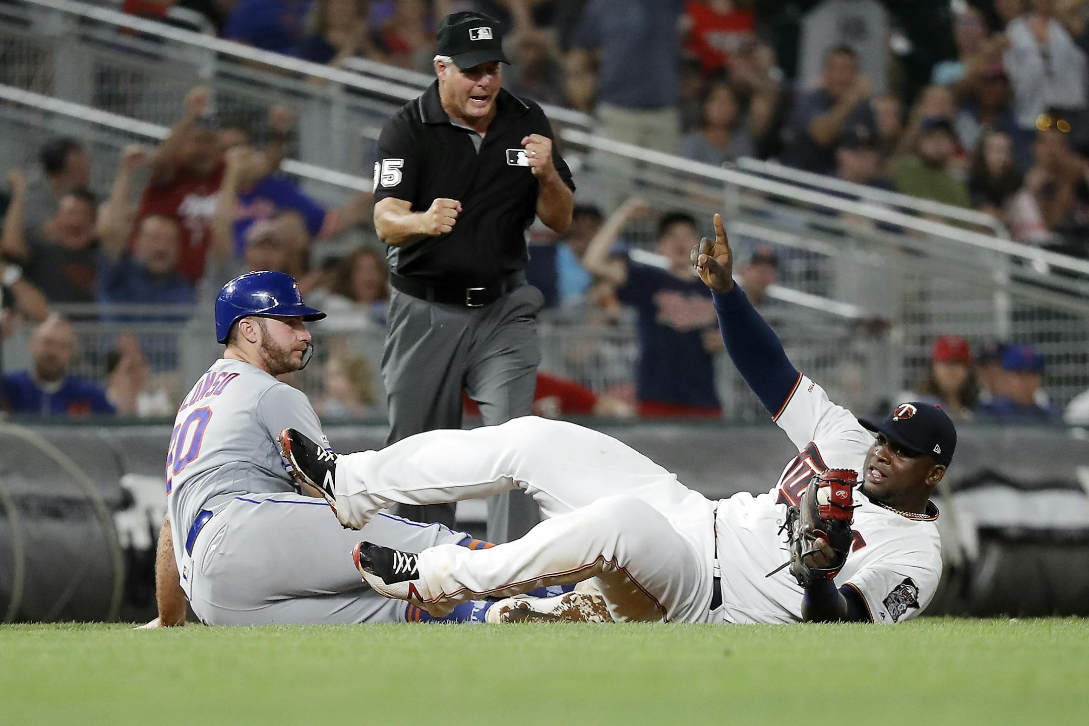 Minnesota Twins third baseman Miguel Sano (22) tags out New York Mets first baseman Pete Alonso (20) at third base for a double play in the eighth inning.