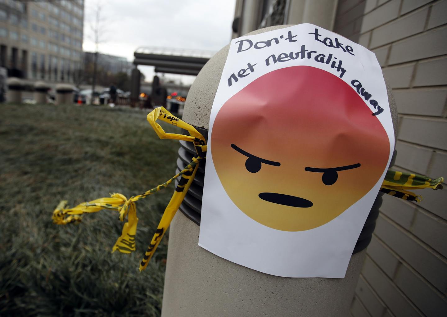 A sign with an emoji reads "Don't take net neutrality away" is posted outside the Federal Communications Commission (FCC), in Washington, Thursday, Dec. 14, 2017, Thursday, Dec. 14, 2017. The FCC voted to eliminate net-neutrality protections for the internet. (AP Photo/Carolyn Kaster)