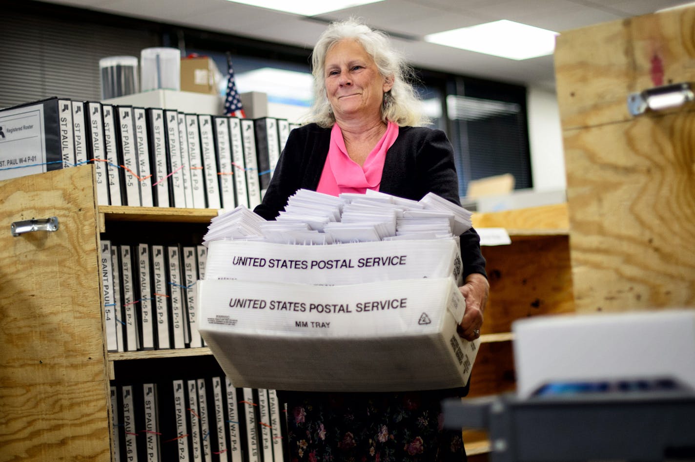 Absentee ballot board judge Peggy Gray brought trays of absentee ballots for processing. ] GLEN STUBBE * gstubbe@startribune.com Processing absentee ballots at the Ramsey County elections office Monday October 20, 2014