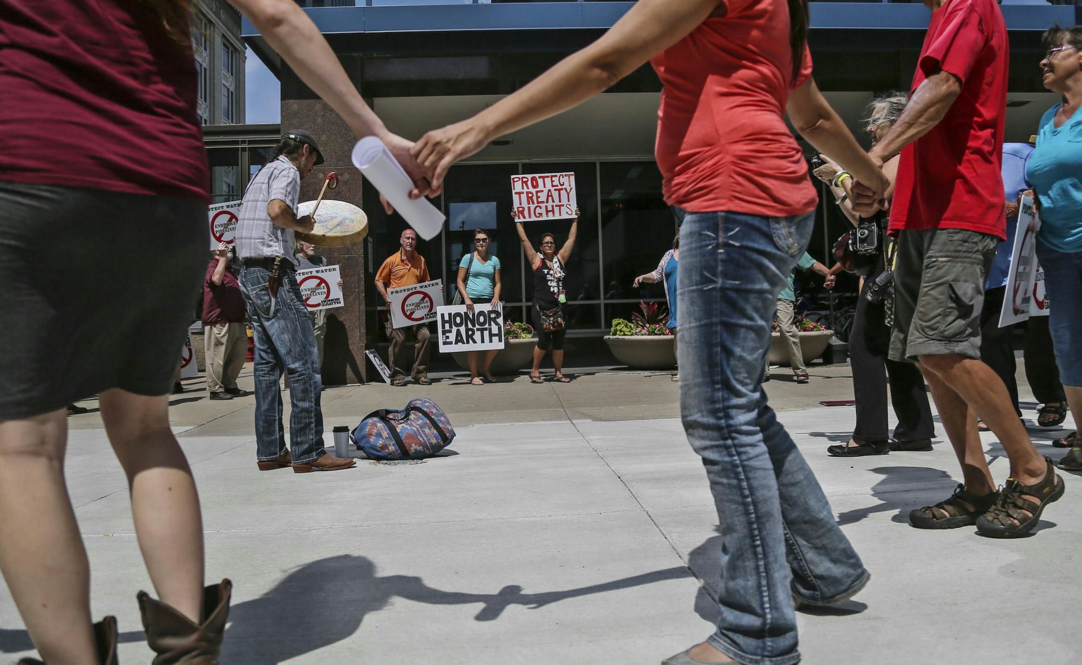 The Minnesota Public Utilities Commission met to consider alternative routes on the proposed Sandpiper pipeline across northern Minnesota to carry Bakken oilThursday, Aug. 7, 2014, in St. Paul. Here, Michael Dahl of White Earth plays a hand drum as anti-pipeline activists dance a circle dance outside the commission meeting room prior to the start.] (DAVID JOLES/STARTRIBUNE) djoles@startribune The Minnesota Public Utilities Commission met to consider alternative routes to for the Sandpiper pipeli