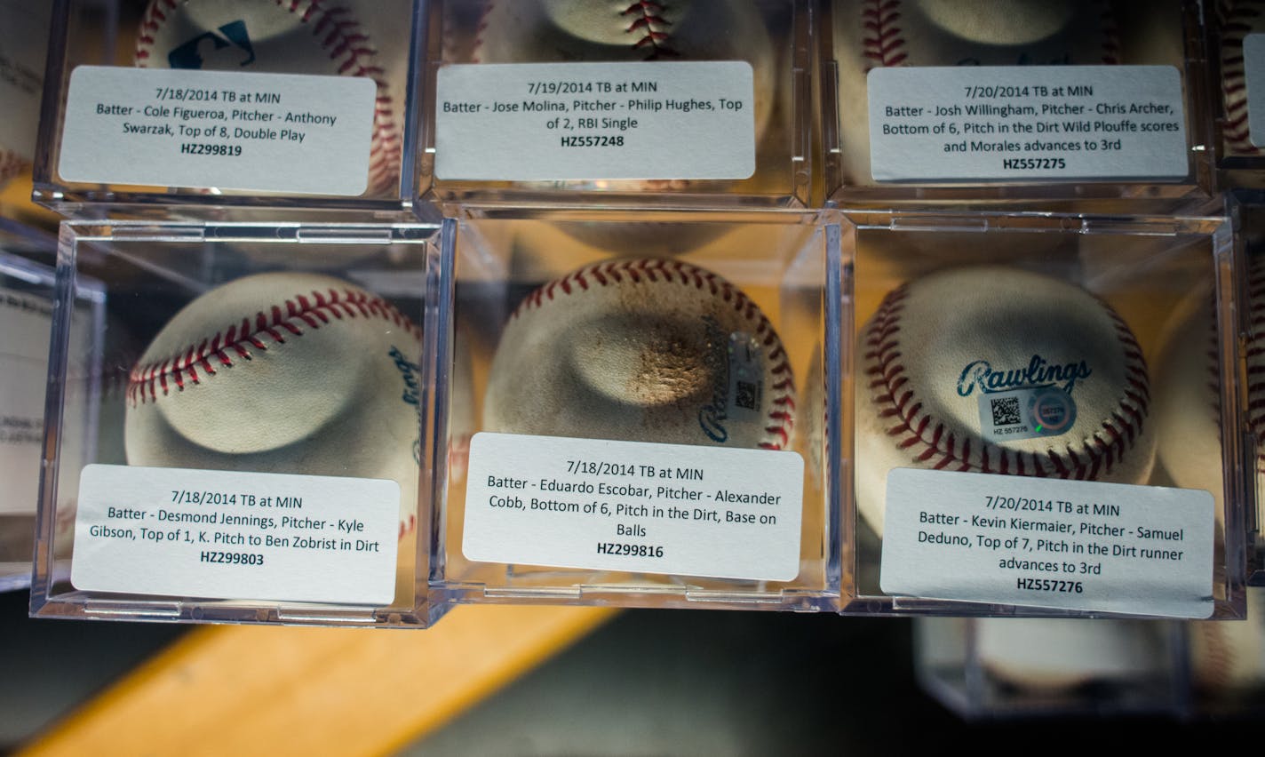 AUTH090114 * 20035859A * 964956 * Mark Vancleave - mark.vancleave@startribune.com * Twins authenticator Steven Bantle collects and tags game memorabilia during a Twins-Royals game Sun. Aug. 17, 2014 at Target Field. [Previously authenticated balls sit on display in the Twins Game Used Items kiosk.]