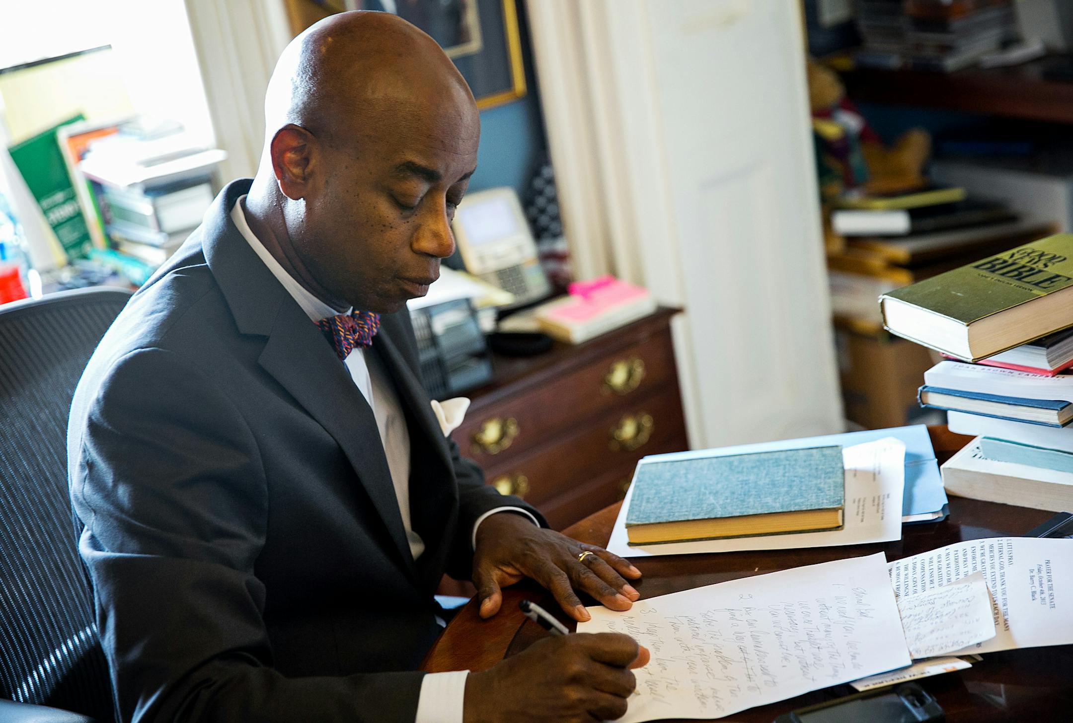 Barry Black, Senate chaplain, writes a morning prayer at his office on Capitol Hill in Washington, Oct. 4, 2013. Black is urging Congress to find a way to re-open the government, turning the morning invocation into a daily conscience check for the 100 men and women of the United States Senate. (Drew Angerer/The New York Times)