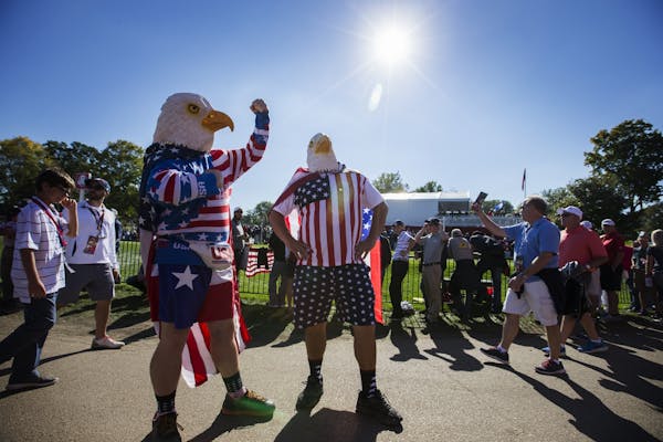 Two American fans sport eagle costumes.