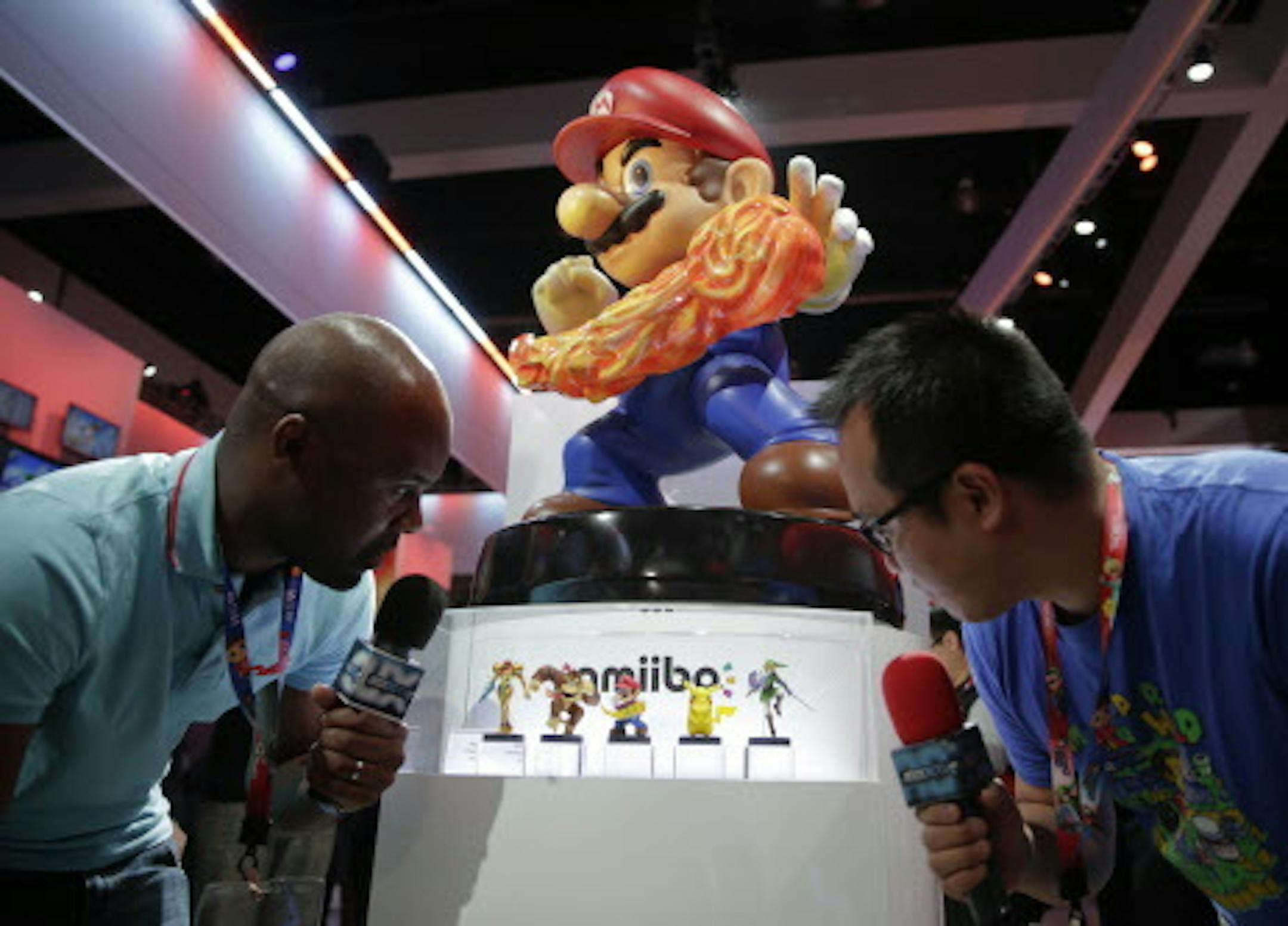 French television reporters look at Amiibo characters for Wii U at the Nintendo booth during the Electronic Entertainment Expo on Tuesday, June 10, 2014, in Los Angeles. (AP Photo/Jae C. Hong)