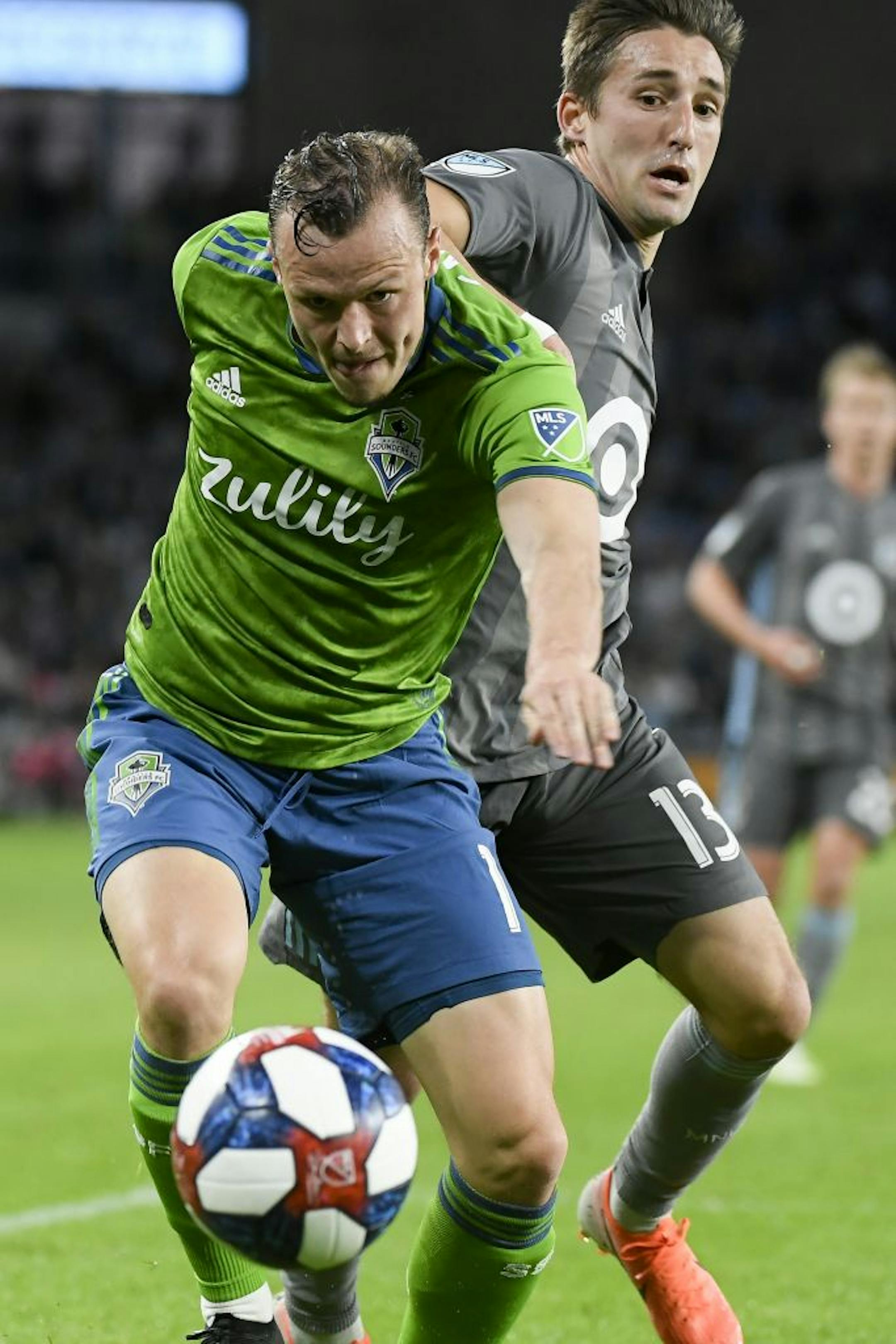 Seattle Sounders defender Brad Smith (11) and Minnesota United midfielder Ethan Finlay (13) chased down the ball near Seattle's goal in the second half.