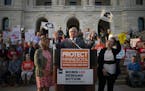 Gov. Tim Walz addressed a rally against gun violence on Wednesday night at the Minnesota State Capitol, flanked by Lt. Gov. Peggy Flanagan, left, and 