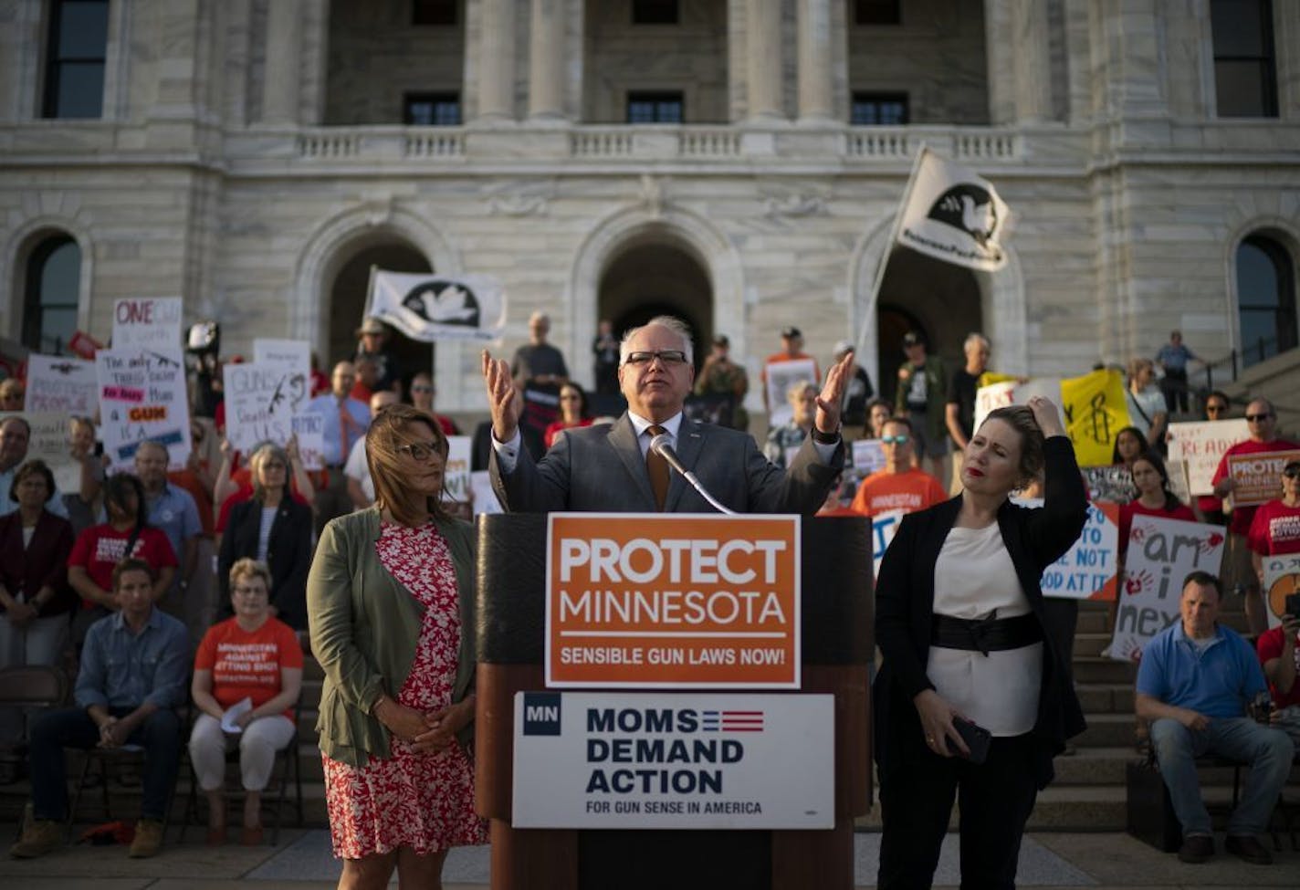 Gov. Tim Walz addressed a rally against gun violence on Wednesday night at the Minnesota State Capitol, flanked by Lt. Gov. Peggy Flanagan, left, and his wife, Gwen Walz.