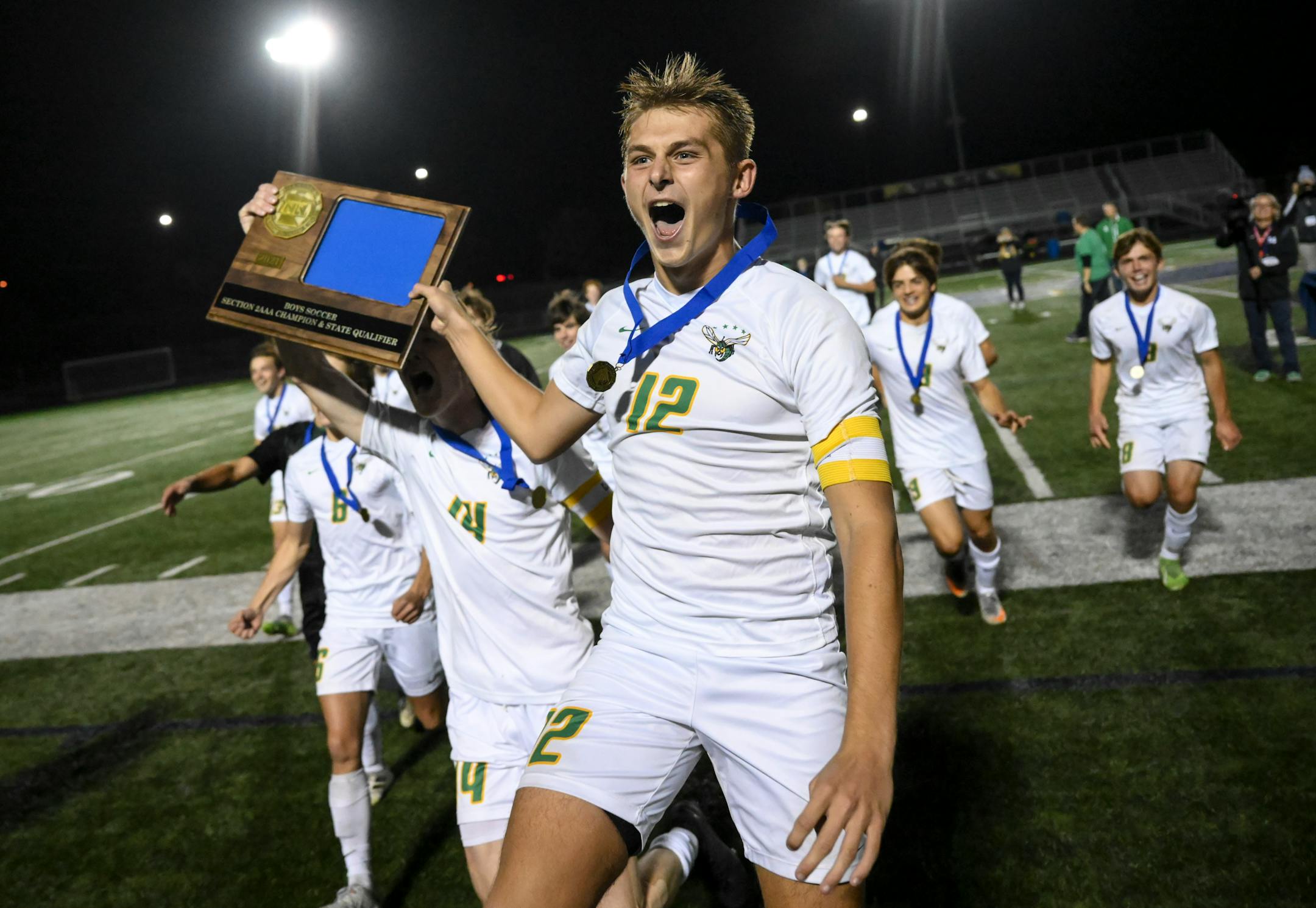 Edina midfielder Ryan Swanda (12) and defender Jackson Holley (14) run with their trophy toward the student section following their 3-2 penalty kick victory against Minnetonka in the Class 3A, Section 2 Championship soccer game at Prior Lake High School Tuesday Oct. 19, 2021, in Savage, Minn. ] AARON LAVINSKY • aaron.lavinsky@startribune.com