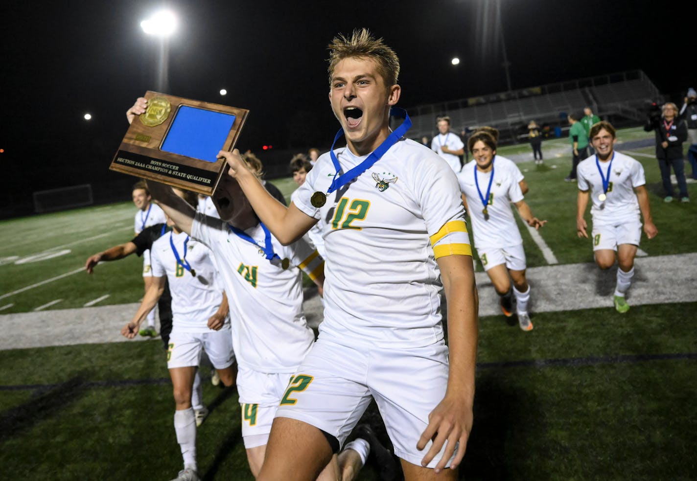 Edina midfielder Ryan Swanda (12) and defender Jackson Holley (14) run with their trophy toward the student section following their 3-2 penalty kick victory against Minnetonka in the Class 3A, Section 2 Championship soccer game at Prior Lake High School Tuesday Oct. 19, 2021, in Savage, Minn. ] AARON LAVINSKY • aaron.lavinsky@startribune.com