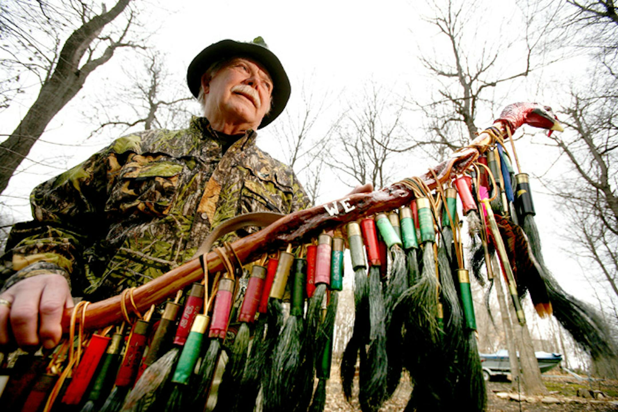 Turkey hunting expert Dick Alford of Mound held a willow stick mounted with the beards and shotgun shells of more than 100 gobblers he has killed over the years.