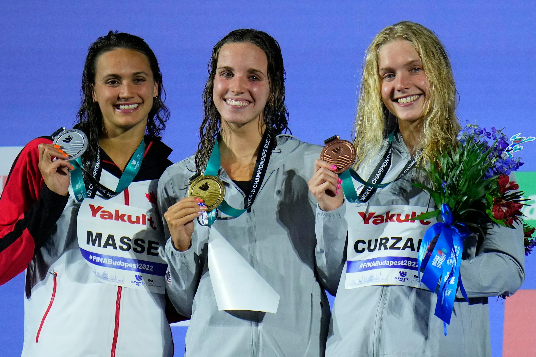 Silver medalist Kylie Masse, gold medalist Regan Smith of the United States and bronze madalist Claire Curzan pose on the podium of the women 100m backstroke final at the FINA World Championships in Budapest
