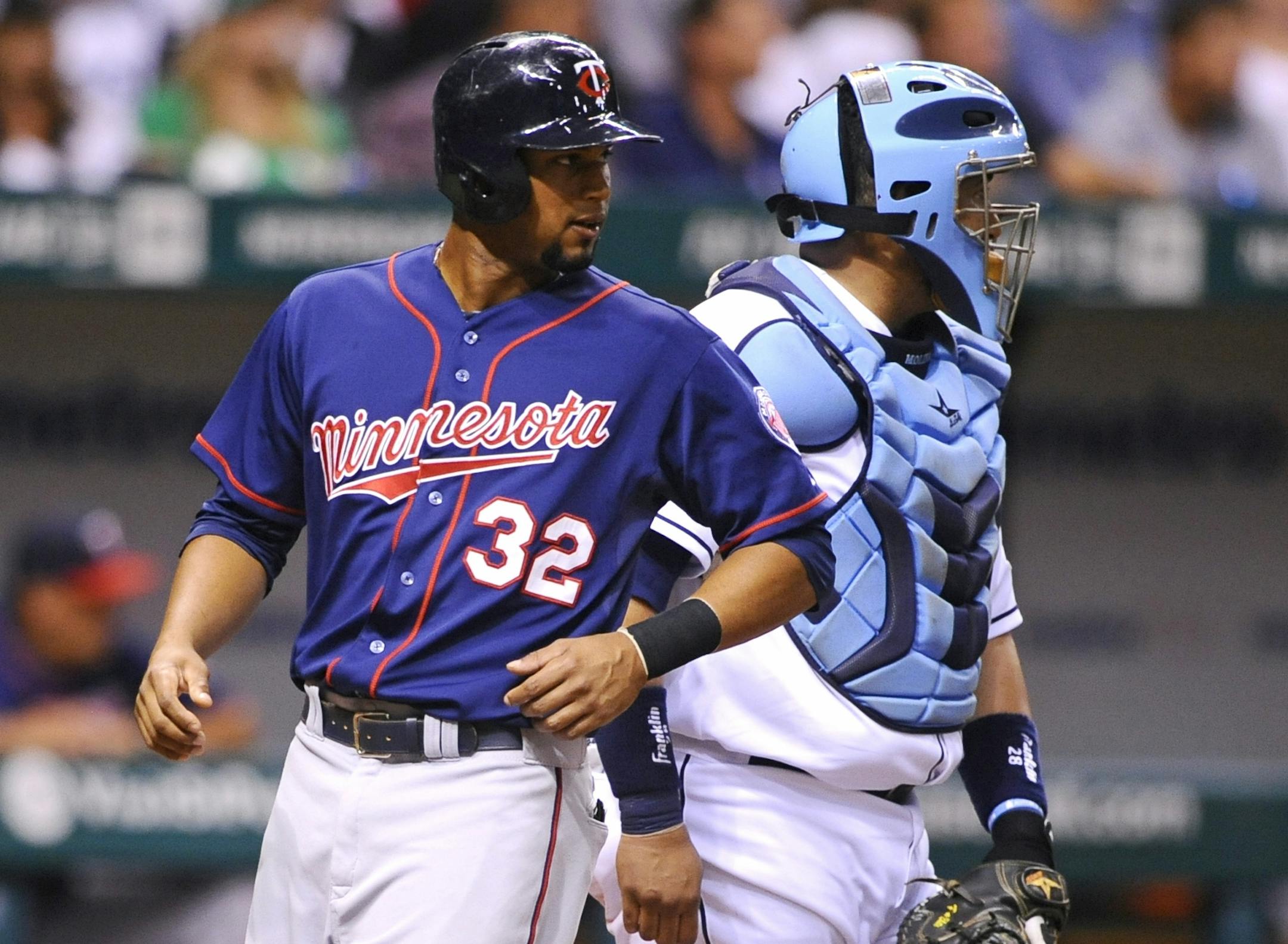 Tampa Bay Rays catcher Jose Molina, right, watches as Minnesota Twins' Aaron Hicks scores off of Brian Dozier' double during the third inning of a baseball game Monday, July 8, 2013, in St. Petersburg, Fla. (AP Photo/Brian Blanco)