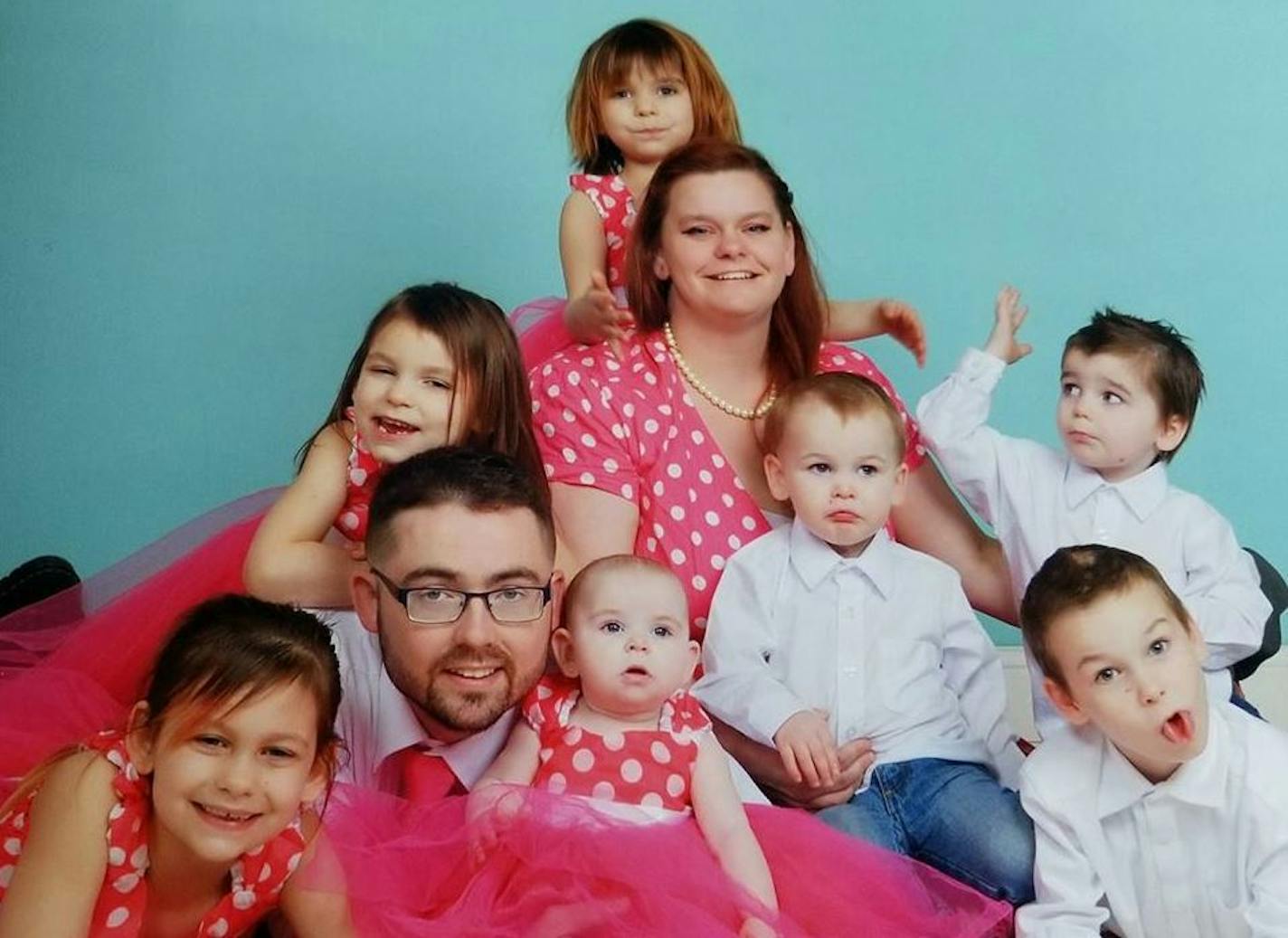 Kyle and Nicolle Peltier, surrounded for this portrait photo by their seven children: Jullianna (lower left), Ellianna (center left), Lillianna (top), Konnor (center right), Kyle Jr. (lower right), Kayden (on mother's lap), and Millianna (with her father).