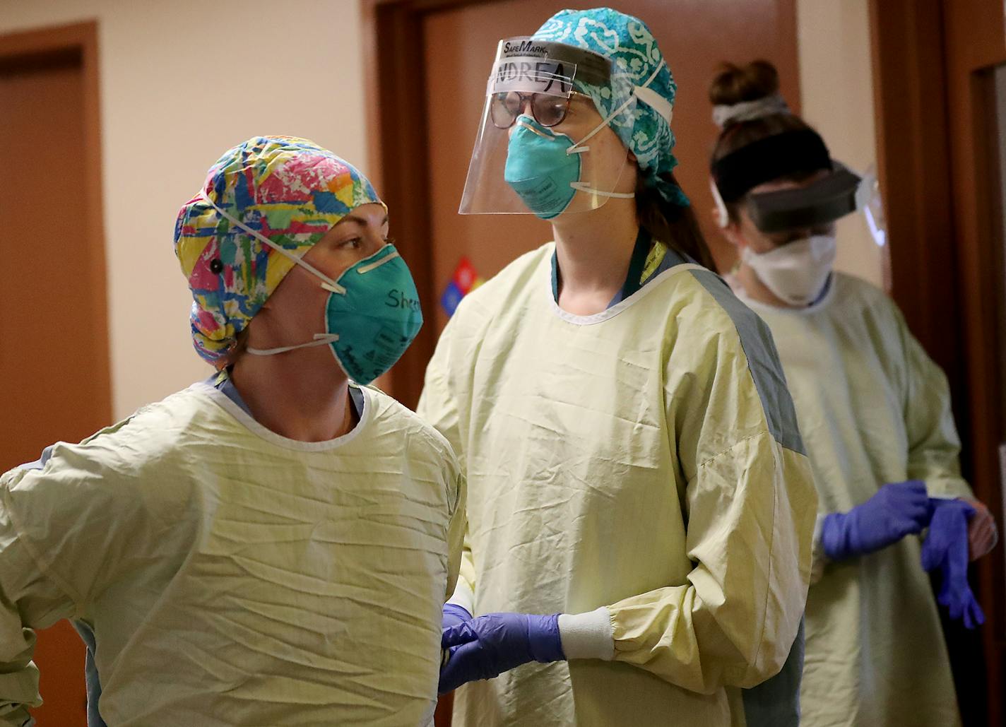 Health-care workers don personal protective equipment on the fifth floor ICU at Bethesda Hospital in St. Paul.