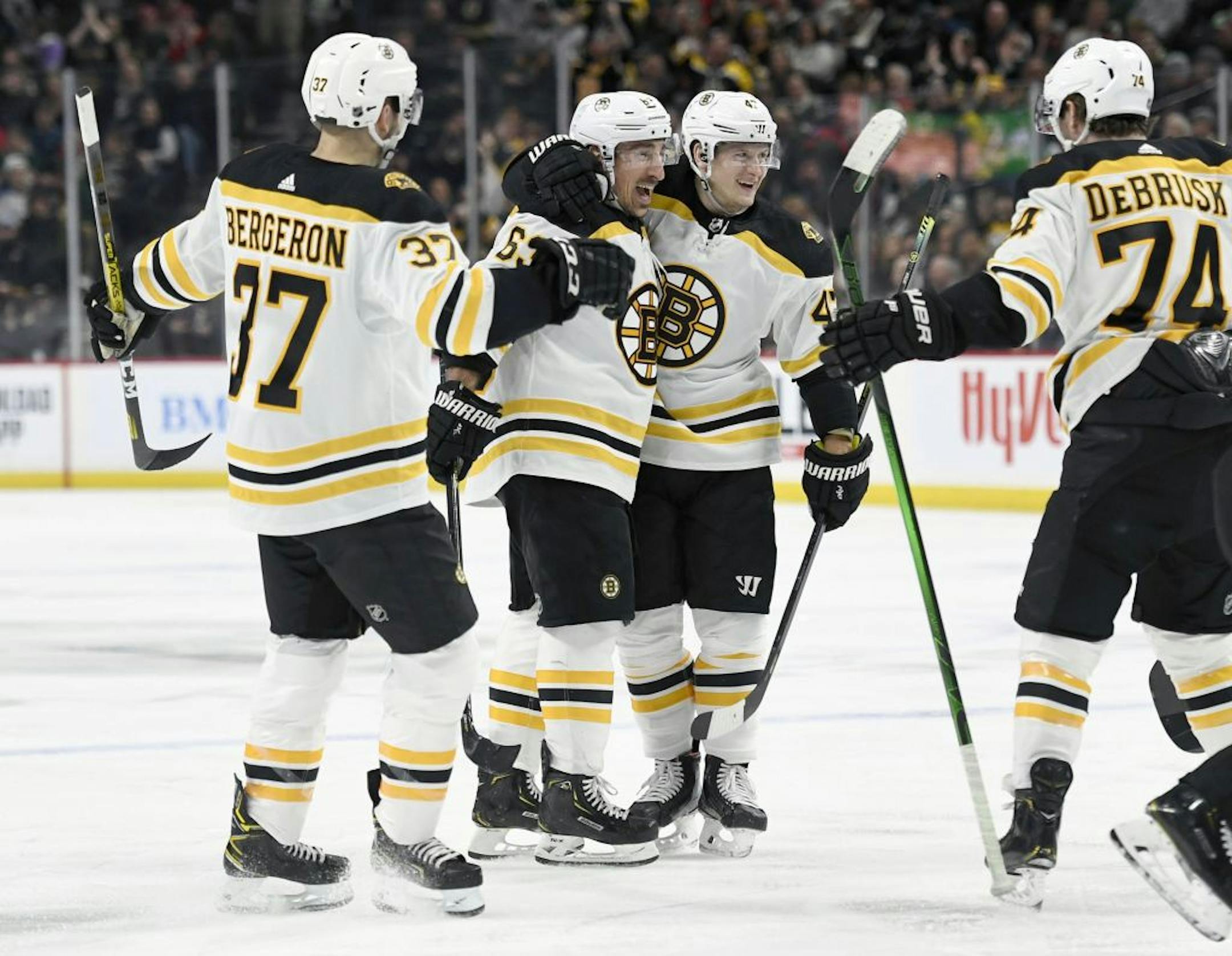 Boston Bruins' Patrice Bergeron (37), Brad Marchand (63), Torey Krug (47) and Jake DeBrusk (74) celebrate a gaol against the Minnesota Wild by Marchand during the second period of an NHL hockey game Saturday, Feb. 1, 2020, in St. Paul, Minn. (AP Photo/Hannah Foslien) ORG XMIT: MER2a66aa8a84822a4a6d529eeaff288