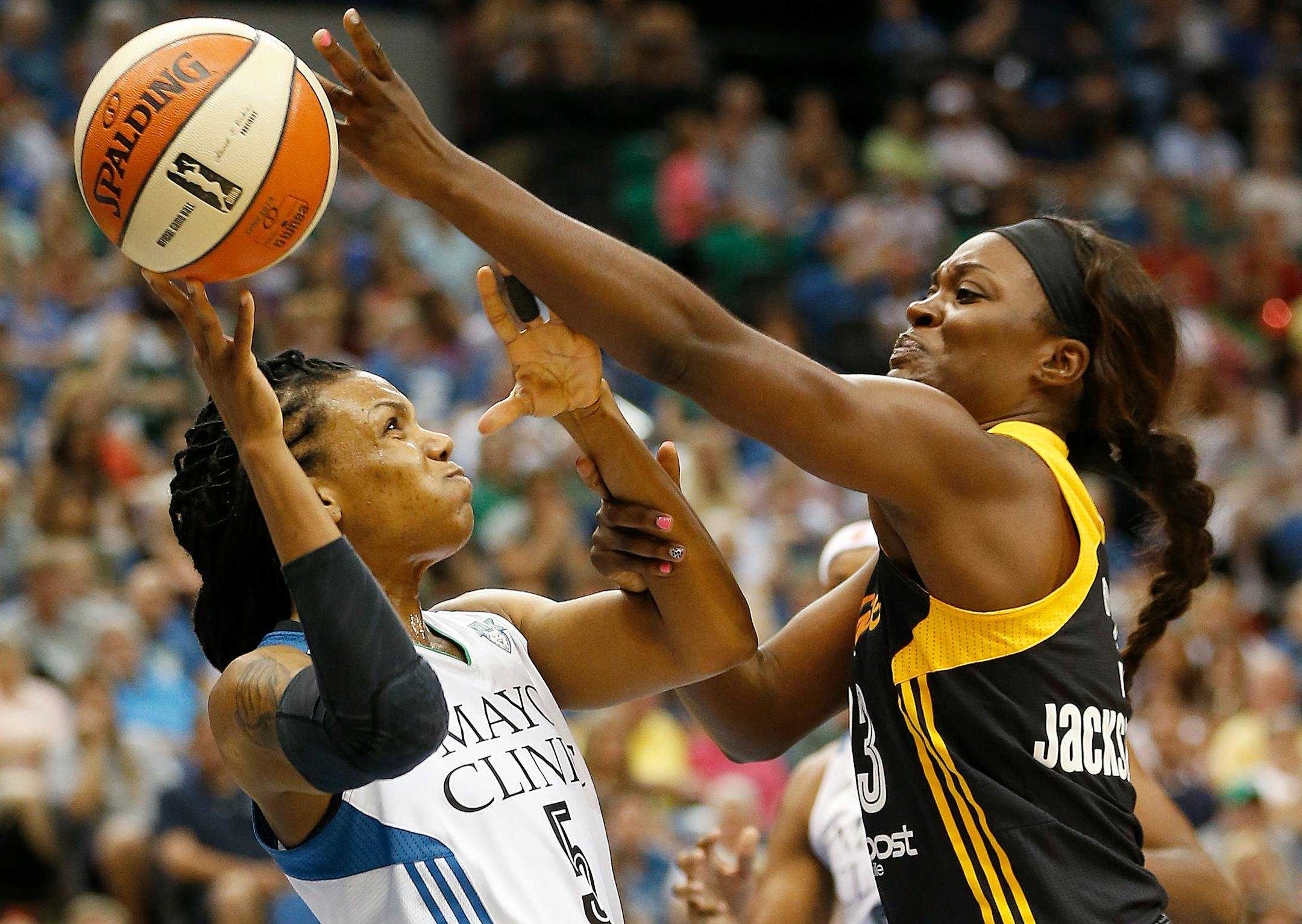 Minnesota Lynx guard Tan White (5) tries to pass the ball against Tulsa Shock forward Tiffany Jackson-Jones (33) in the first half of a WNBA basketball game, Saturday, Aug. 16, 2014, in Minneapolis. (AP Photo/Stacy Bengs)