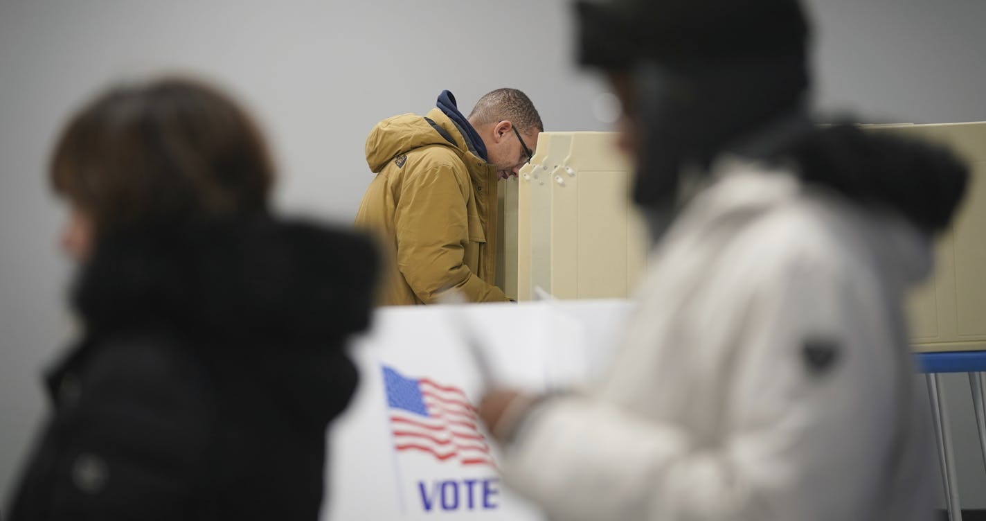 Jared Mollenkof votes at the Minneapolis Early Voting Center, Friday, Jan. 17, 2020, in Minneapolis. Mollenkof and Davis Senseman arrived the night before so they could be among the first voters in the 2020 election, when the center opened at 8 a.m. They planned to vote for Democratic presidential candidate Elizabeth Warren in the state's primary. (Glen Stubbe/Star Tribune via AP)