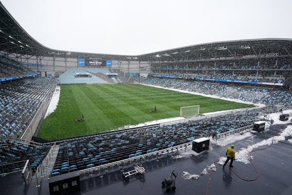 Members of the grounds crew cut the grass Friday at Allianz Field amid heavy snow flurries ahead of Saturday's home opener. ] ANTHONY SOUFFLE • anth