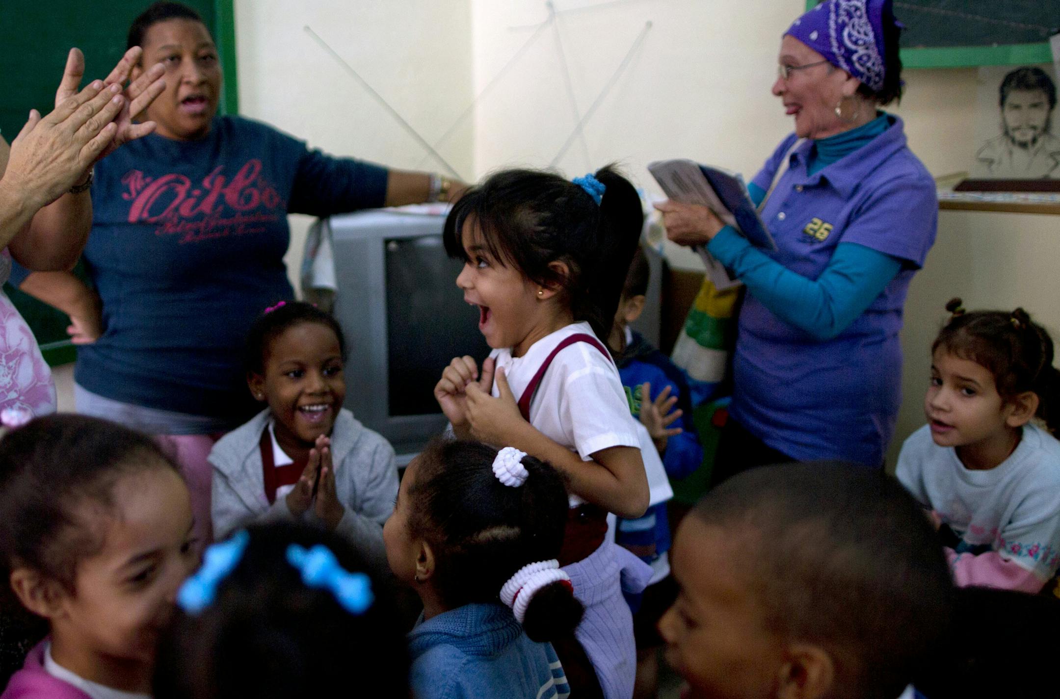 Students and teachers celebrate after listening to a live, nationally broadcast speech by Cuba's President Raul Castro about the country's restoration of relations with the United States, at a school in Havana, Cuba, Wednesday, Dec. 17, 2014. Castro said profound differences remain between Cuba and the U.S. in areas such as human rights, foreign policy and questions of sovereignty, but that the countries have to learn to live with their differences "in a civilized manner." (AP Photo/Ramon Espino