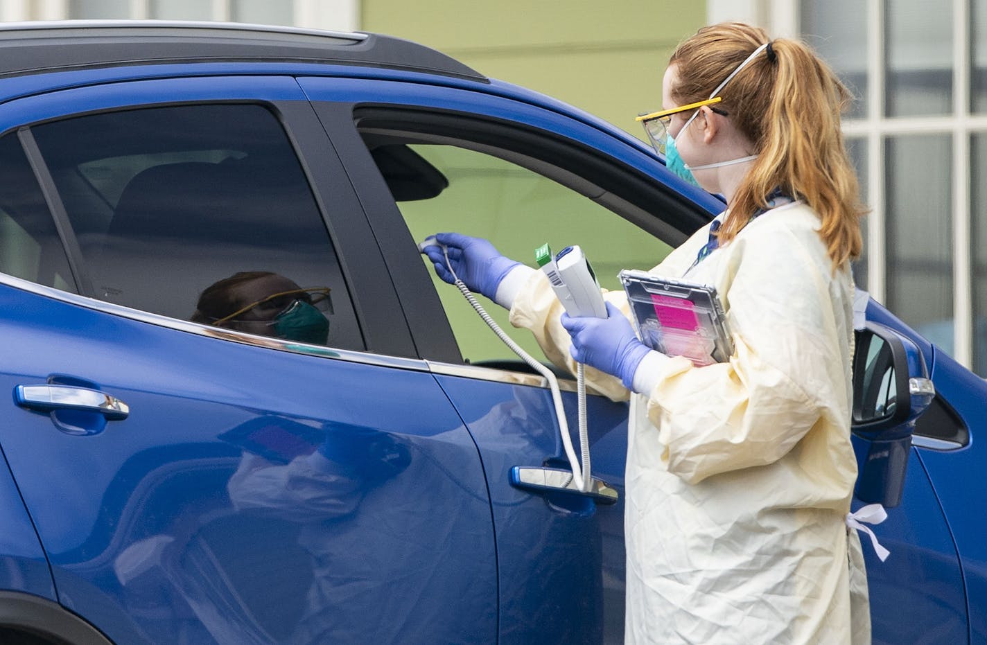 Medical Assistant Courtney Banks took the temperature of a patient at a drive up COVID-19 testing site in front of St. Luke's Miller Creek Medical Clinic in Duluth.