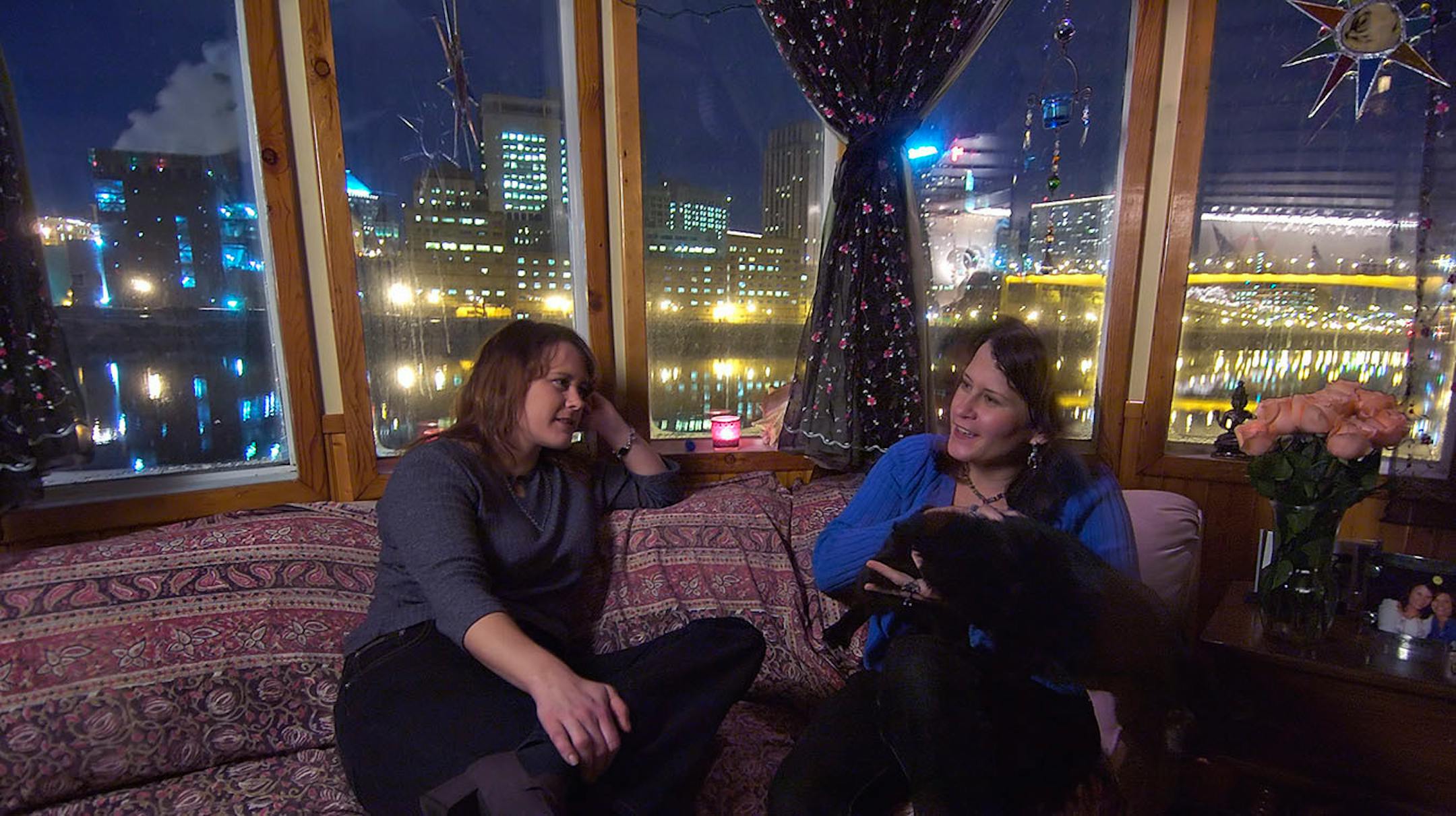 Liz Miller (right) chats with her sister, Martha Miller (left), in her living room inside the Covington Inn, a floating B&B next to downtown St. Paul. (From 2005).