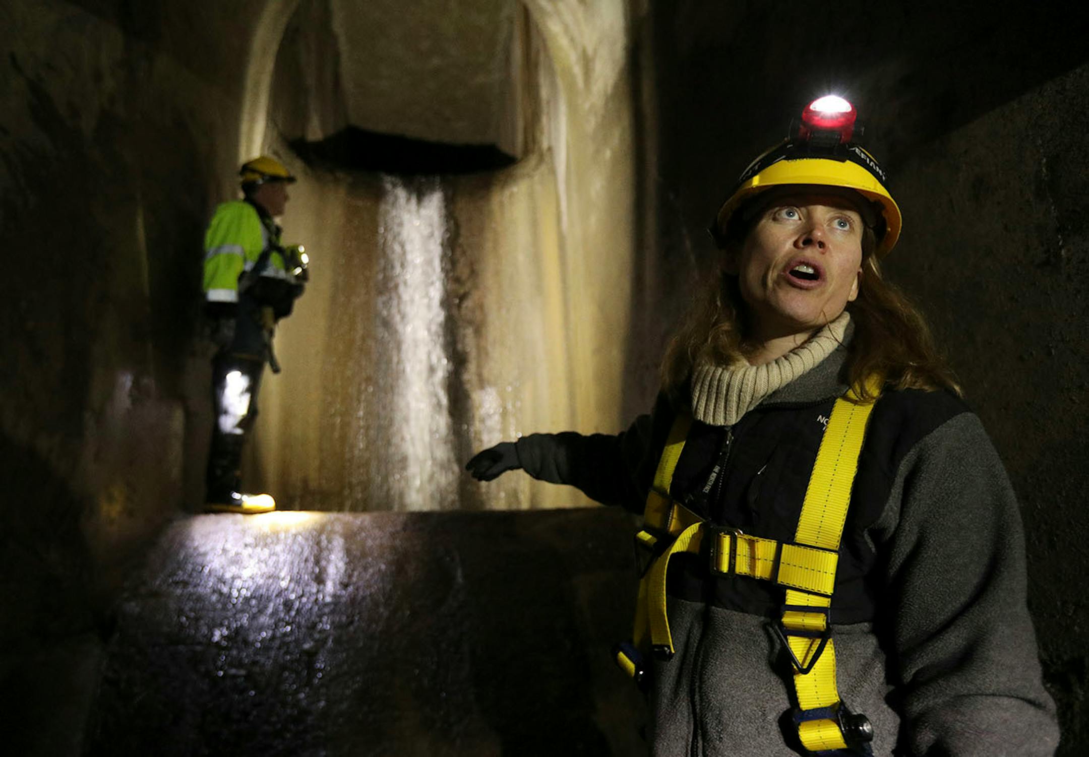 Sewer engineer Joe Klejwa looked over an intake area as Katrina Kessler, director of Surface Water and Sewers for the Minneapolis Public Works Department, explained the process during a tour underground in the northeast.