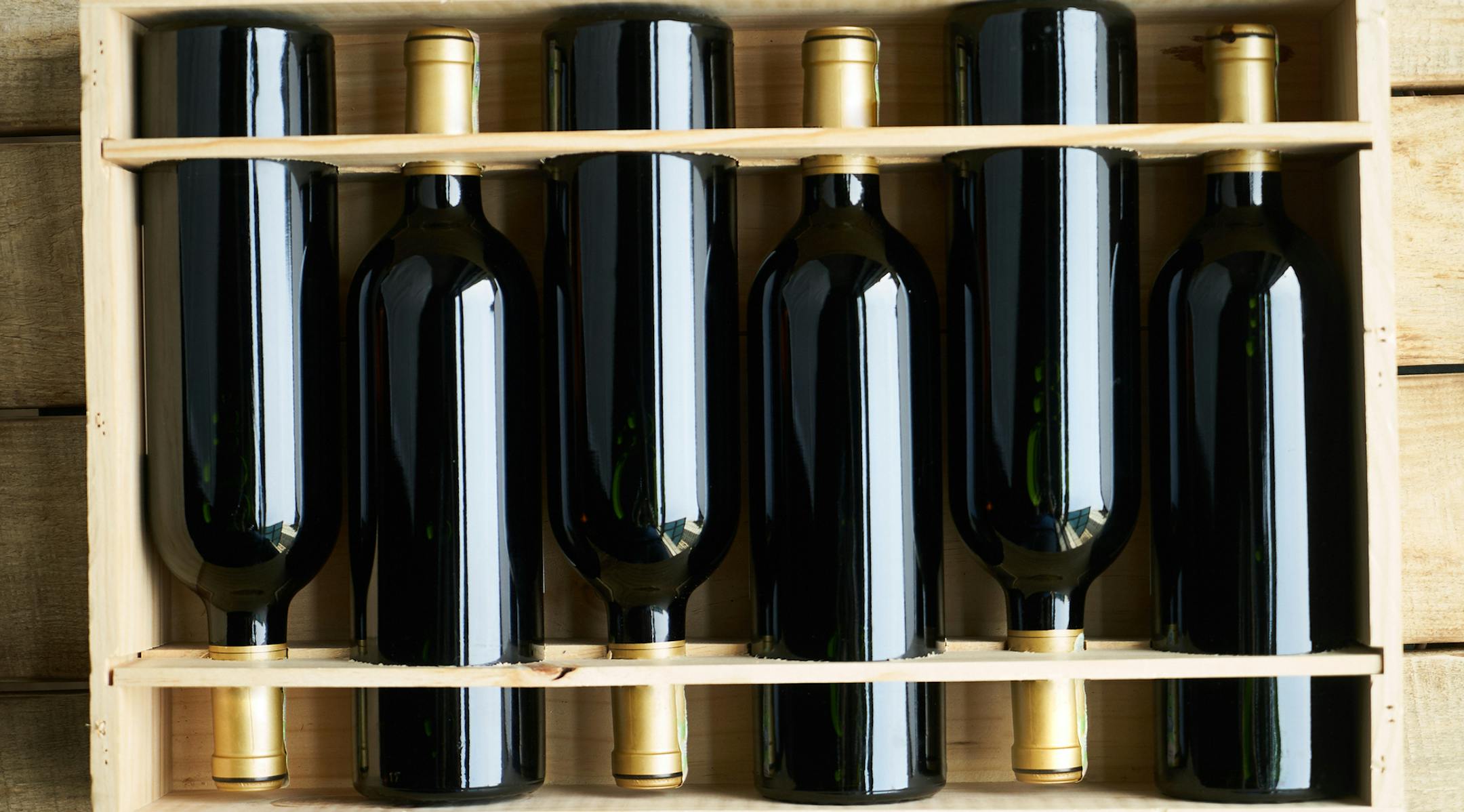 Top view of a case of cabernet sauvignon wine bottles. Wooden box with collection of six wine bottle