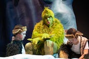 Reed Sigmund, playing the Grinch, chats with Matthew Woody and Audrey Mojica, left to right, child actors playing young Max, during a break on set Thu