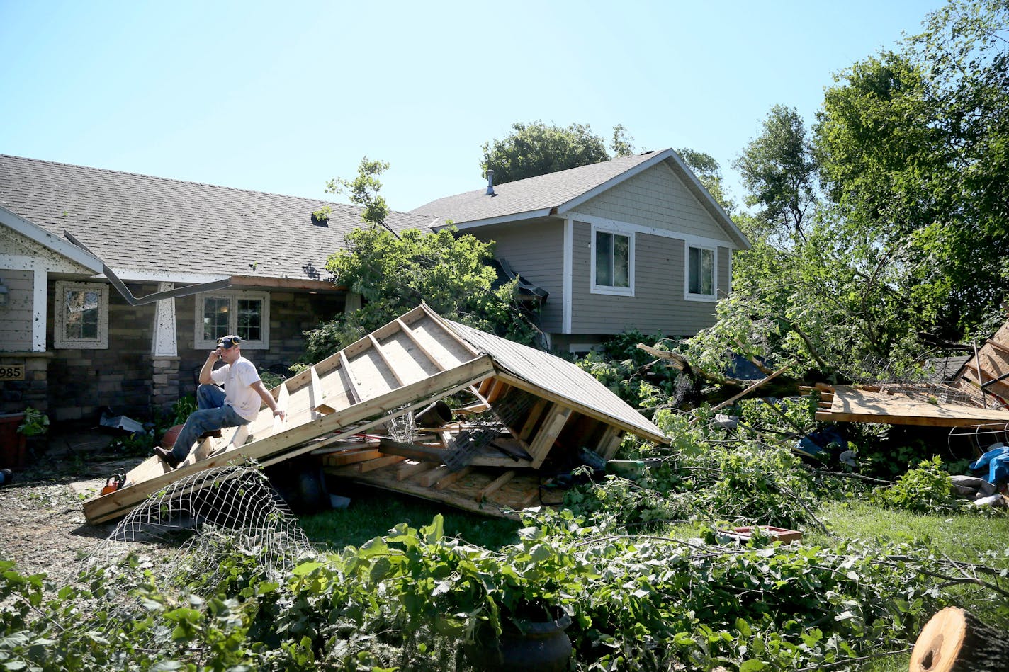 Jason Bogema sits atop a destroyed building on his property in Hollywood Township, where an EF-1 tornado with 105 mph winds touched down overnight Saturday, July 18, 2015.