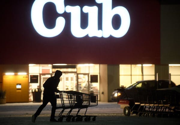 An employee pushed together shopping carts Wednesday night at the Cub location next to the Northtown Mall in Blaine.